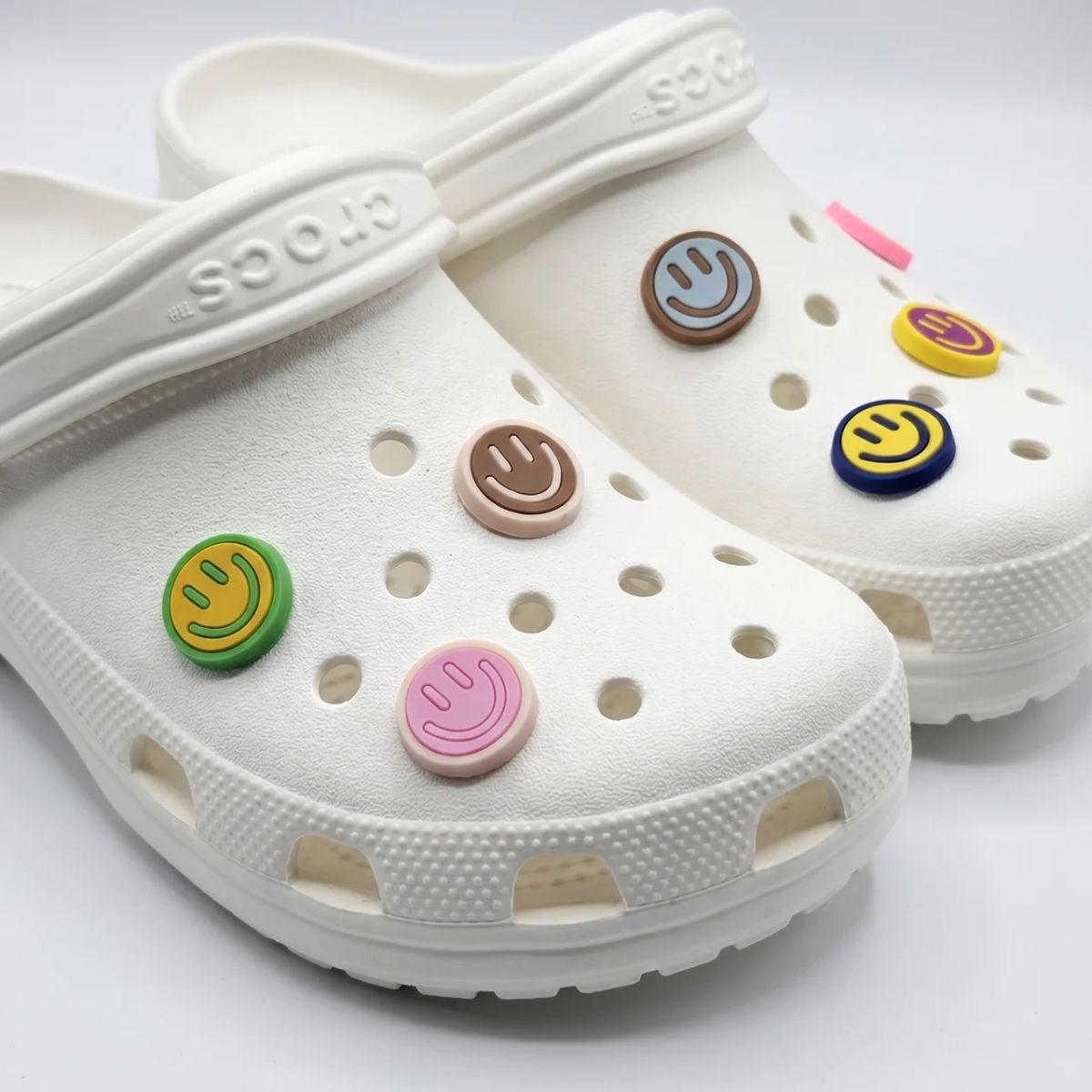 Crocs with colorful smiley face charms by Kicks Shoelaces.