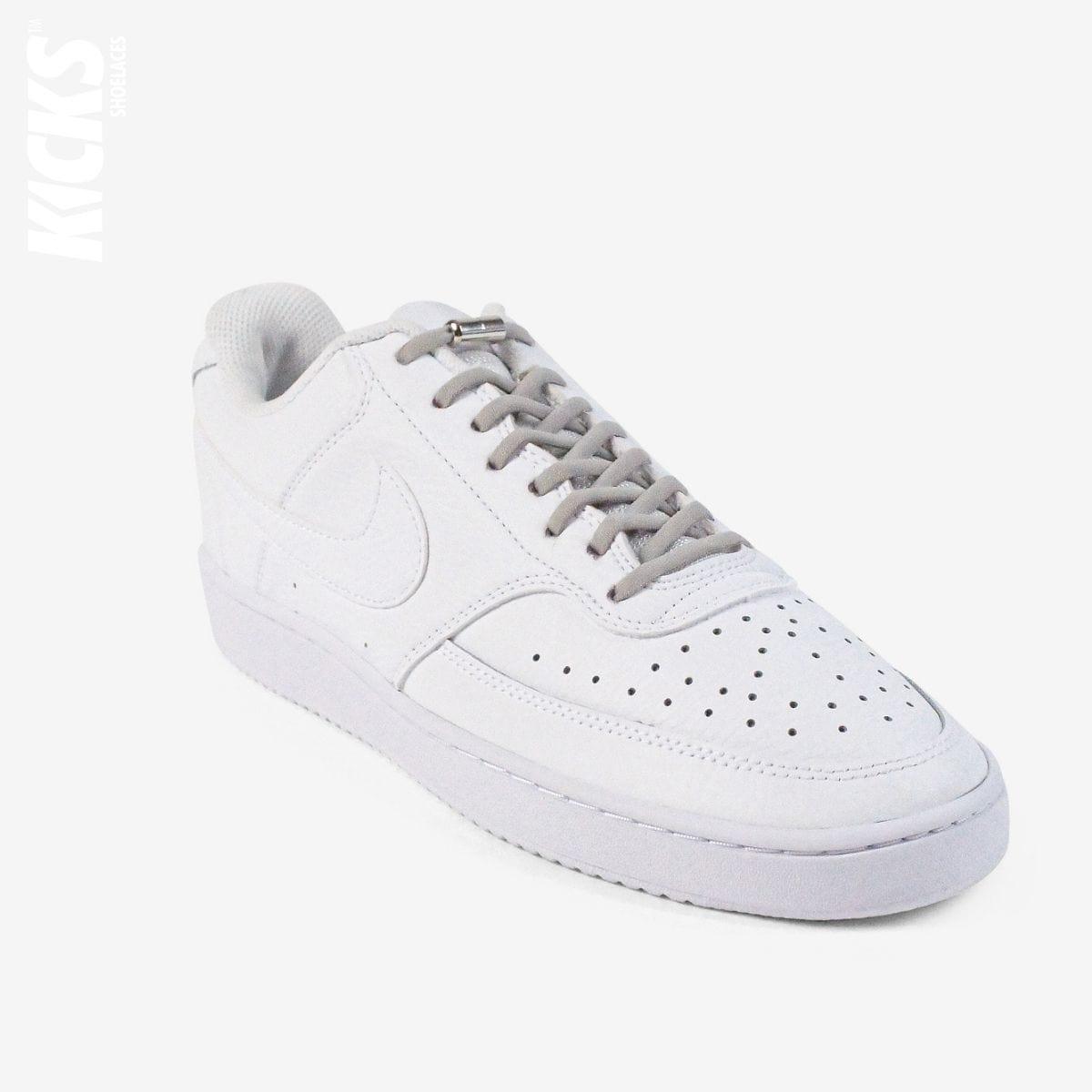 Grey oval no-tie elastic shoelaces installed on white sneakers by Kicks Shoelaces